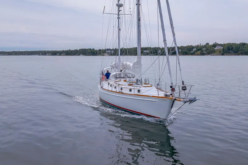 Slide: The Image of Sailing yacht Shannon 47/52 from 2001 cruising on calm waters near a forested shoreline. - 9