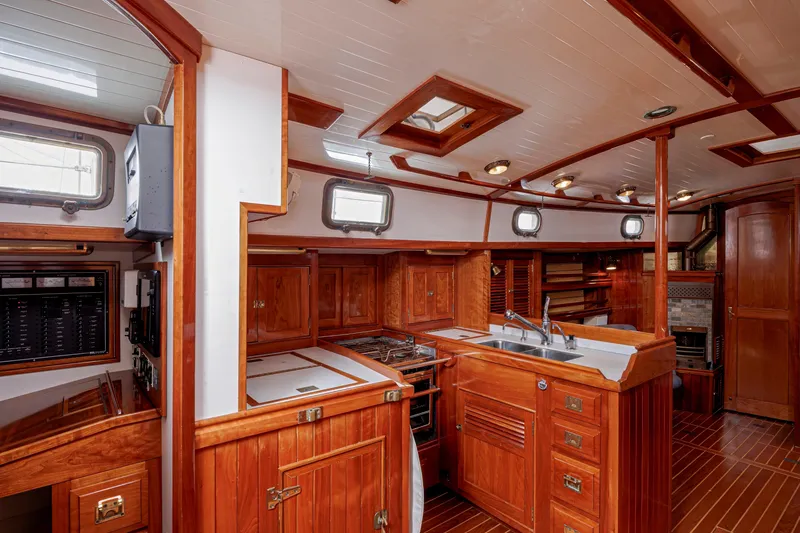 Slide: The Image of Luxurious wooden interior of a 2001 Shannon 47/52 yacht, featuring a well-equipped kitchen. - 35