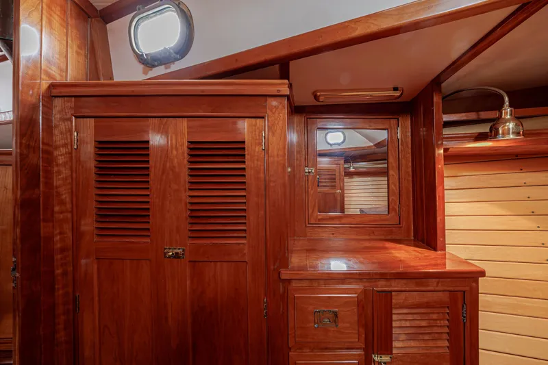Slide: The Image of Luxurious wooden interior of a 2001 Shannon 47/52 yacht cabin with mirror and storage. - 60