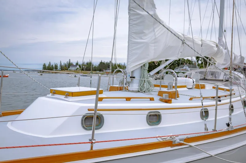 Slide: The Image of Sailboat Shannon 47/52, 2001 model, docked in a serene harbor with lush greenery. - 21