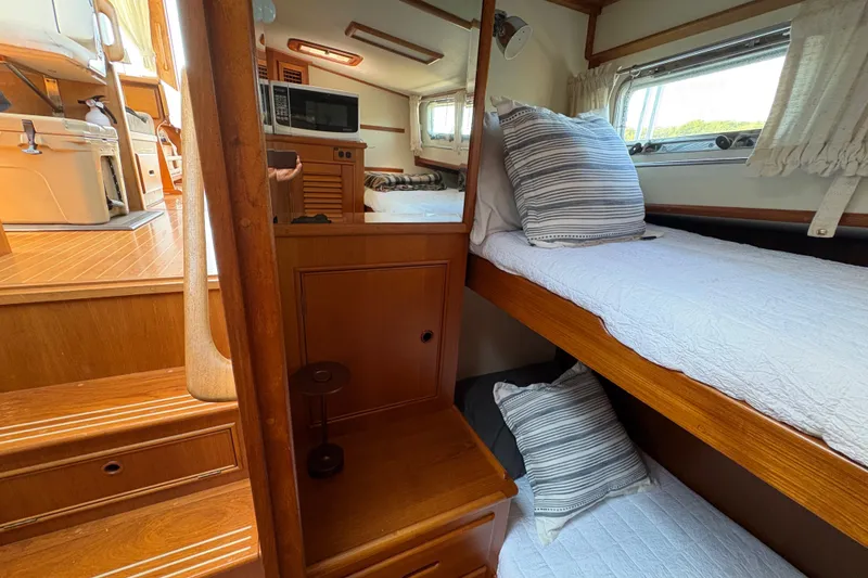 Slide: The Image of Interior of 1996 Grand Banks 40 Eastbay EX with cozy bunk beds and wooden finishes. - 24