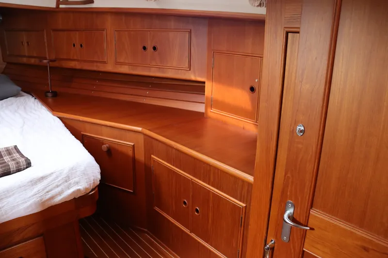 Slide: The Image of Interior of 1996 Eastbay 40 Express Grand Banks, featuring wooden cabinetry and cozy sleeping area. - 28