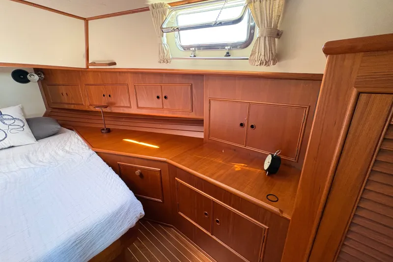 Slide: The Image of Cozy cabin interior of 1996 Grand Banks 40 Eastbay EX with wooden cabinetry and bed. - 29
