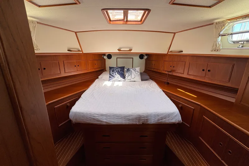Slide: The Image of Luxurious cabin interior of 1996 Grand Banks 40 Eastbay EX yacht with cozy bed and wooden cabinetry. - 27