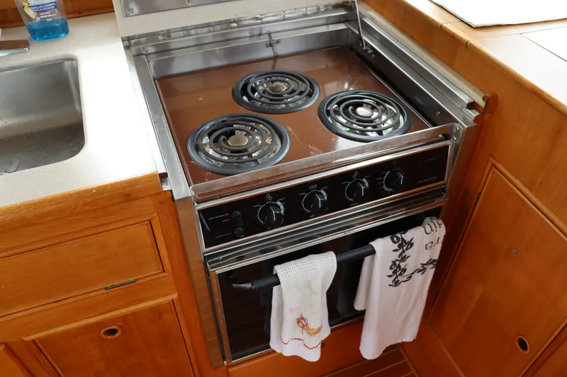 Slide: The Image of Stove and sink in 1996 Eastbay 40 Express Grand Banks yacht kitchen. - 14