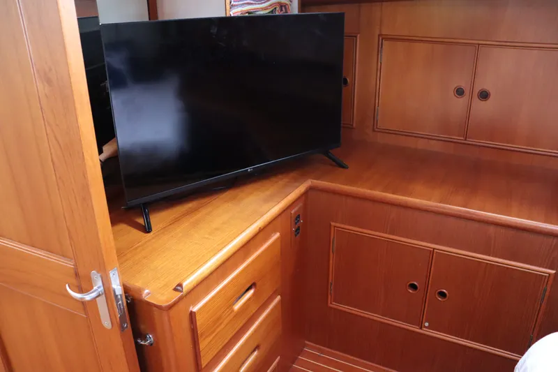 Slide: The Image of Wooden interior of 1996 Eastbay 40 Express Grand Banks with TV on cabinet. - 34