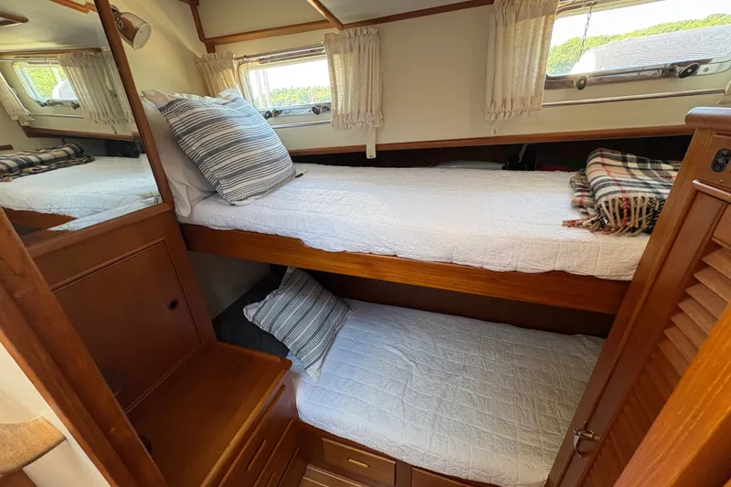 Slide: The Image of Cozy bunk beds in 1996 Grand Banks 40 Eastbay EX cabin with wooden accents. - 25