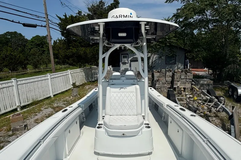 Slide: The Image of 2021 Yellowfin 26 Hybrid boat with Garmin equipment, parked outdoors near a white fence. - 18