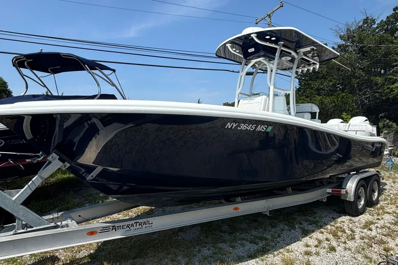 The Image of 2021 Yellowfin 26 Hybrid boat on trailer, sleek design, parked outdoors. - 0