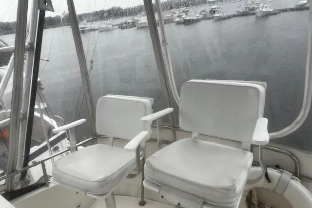 Slide: The Image of 1996 Silverton 41 Convertible boat interior with white seating overlooking marina. - 6