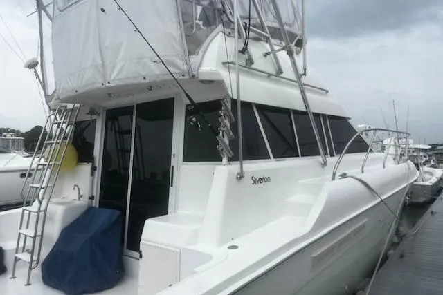 Slide: The Image of 1996 Silverton 41 Convertible yacht docked, featuring sleek design and spacious upper deck. - 1