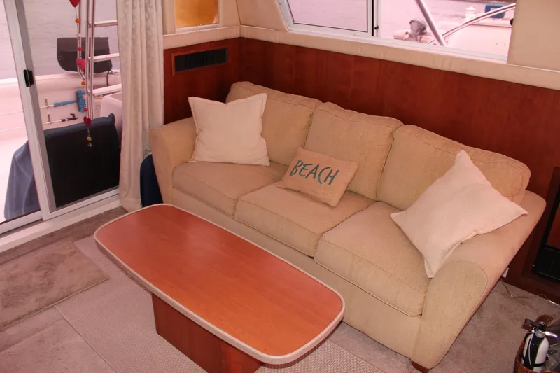 Slide: The Image of Interior of 1996 Silverton 41 Convertible yacht with beige sofa and wooden table. - 43