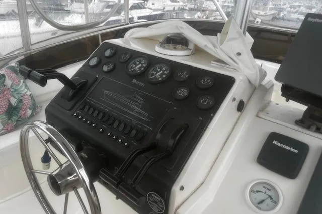 Slide: The Image of 1996 Silverton 41 Convertible boat dashboard with steering wheel and control panel. - 7