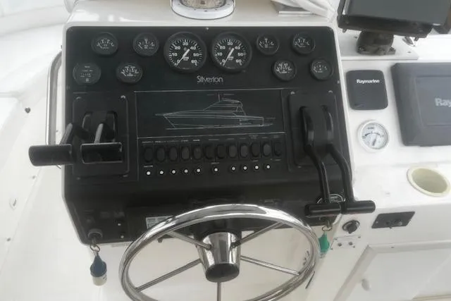 Slide: The Image of Control panel of a 1996 Silverton 41 Convertible boat with steering wheel and gauges. - 8