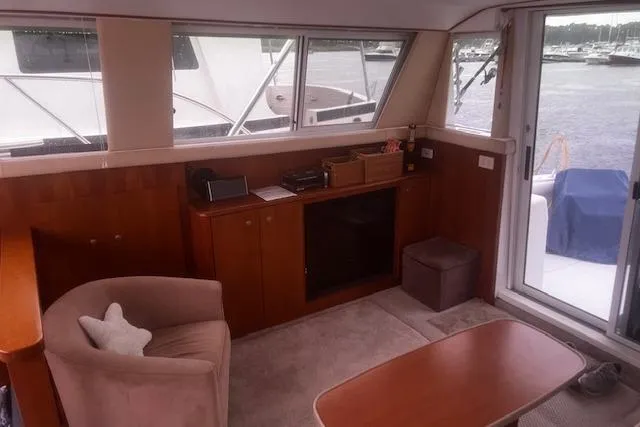 Slide: The Image of Interior of 1996 Silverton 41 Convertible yacht with cozy seating and wooden cabinetry. - 15