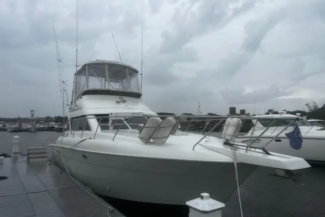 The Image of 1996 Silverton 41 Convertible yacht docked on a cloudy day. - 0