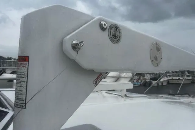 Slide: The Image of 1996 Silverton 41 Convertible boat detail with anchor emblem, docked under cloudy skies. - 5