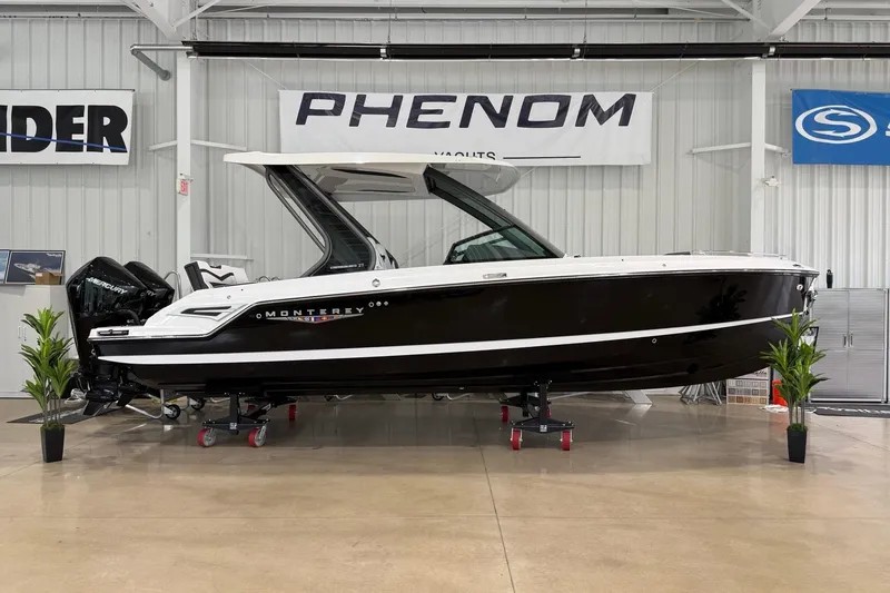 The Image of 2027 Monterey Elite 27 OB boat displayed indoors with sleek black and white design. - 0