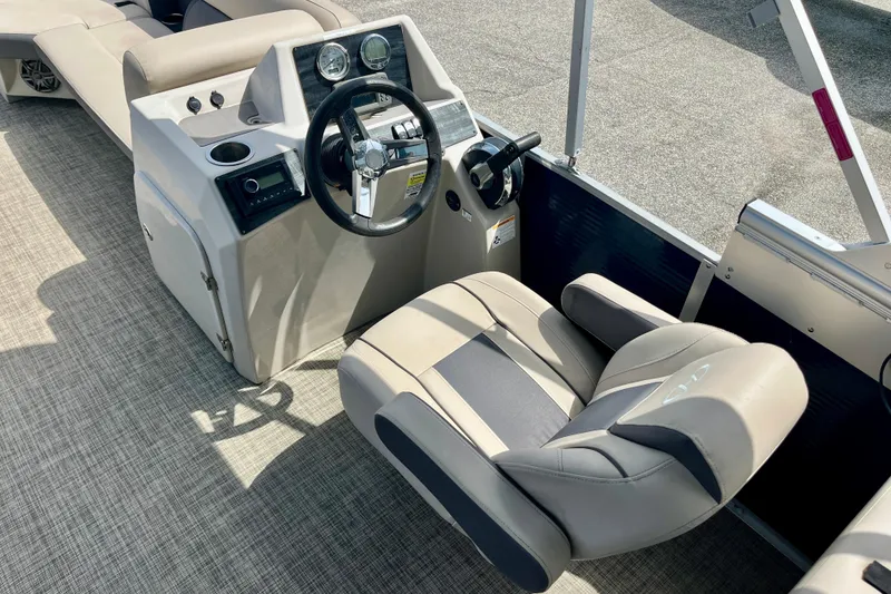 Slide: The Image of 2023 Harris Cruiser 230 boat interior with steering wheel and comfortable seating. - 10