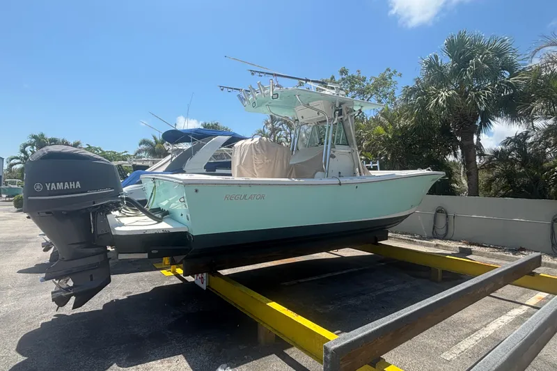 Slide: The Image of 2008 Regulator 26 Forward Seating boat with Yamaha engine on trailer, surrounded by palm trees. - 3