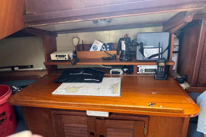 Slide: The Image of Navigation station on a 1976 Islander 36 sailboat with charts and communication equipment. - 5