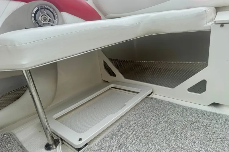 Slide: The Image of 2008 Glastron GT 225 boat interior with white seating and storage compartment. - 32