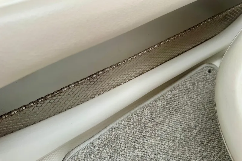 Slide: The Image of Interior detail of a 2008 Glastron GT 225 boat, featuring netted storage and carpeted flooring. - 56