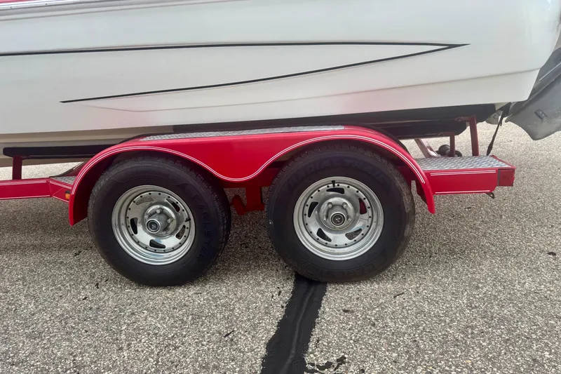 Slide: The Image of Red trailer with dual wheels carrying a 2008 Glastron GT 225 boat. - 13