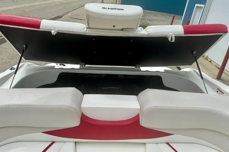 Slide: The Image of 2008 Glastron GT 225 boat interior with open engine compartment, showcasing seating and storage. - 49