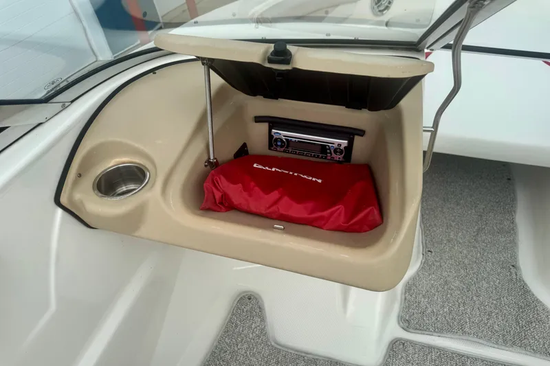 Slide: The Image of Open storage compartment in 2008 Glastron GT 225 boat with stereo and red bag. - 36