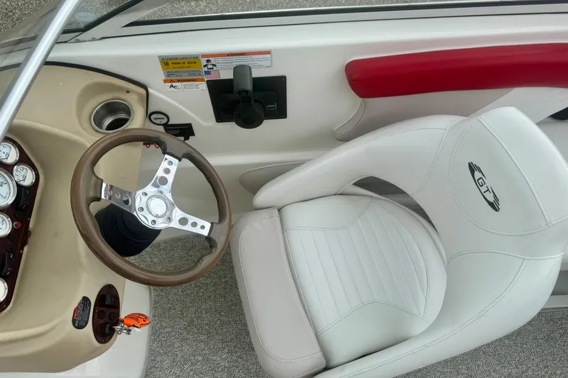 Slide: The Image of 2008 Glastron GT 225 boat interior with steering wheel and white seat. - 27