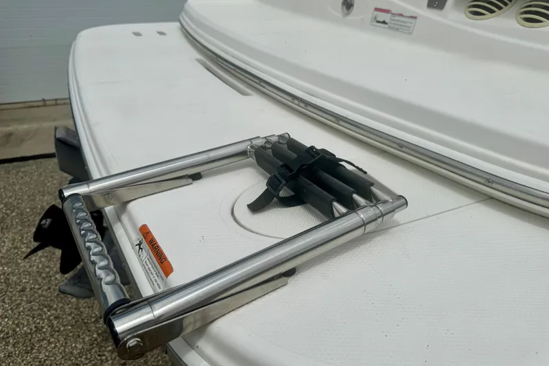 Slide: The Image of 2008 Glastron GT 225 boat swim platform with foldable ladder and safety warning label. - 63
