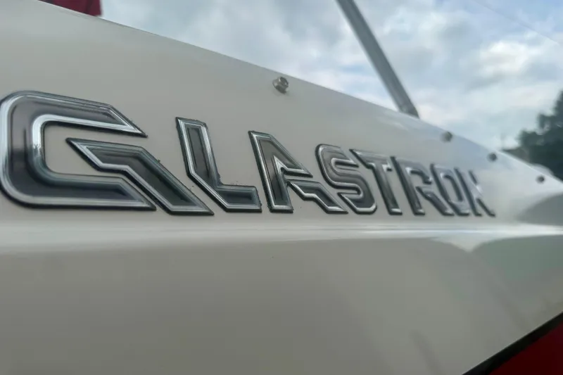 Slide: The Image of Close-up of 2008 Glastron GT 225 boat logo on white surface. - 16
