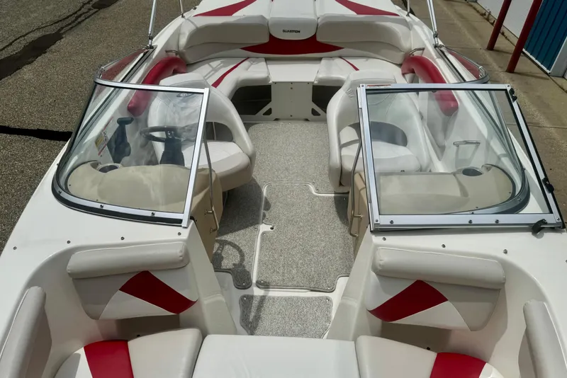 Slide: The Image of 2008 Glastron GT 225 boat interior with red and white seating, open windshield, and steering wheel. - 46