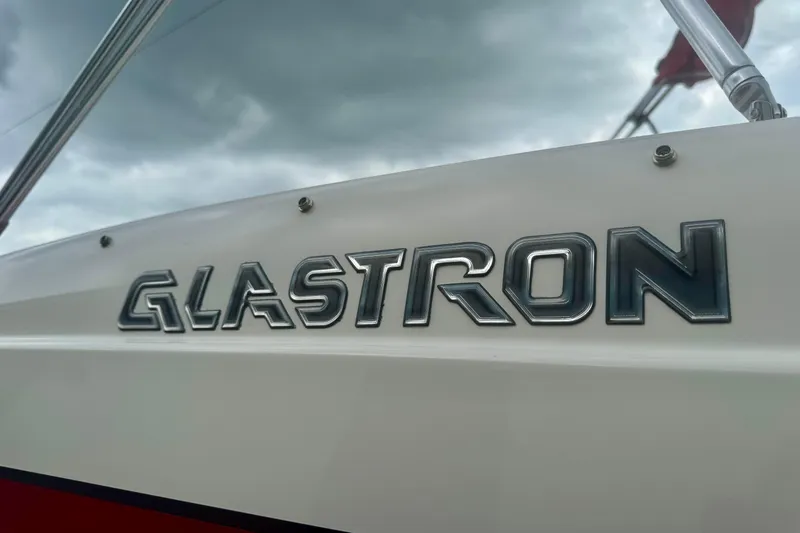 Slide: The Image of 2008 Glastron GT 225 boat logo against cloudy sky background. - 11