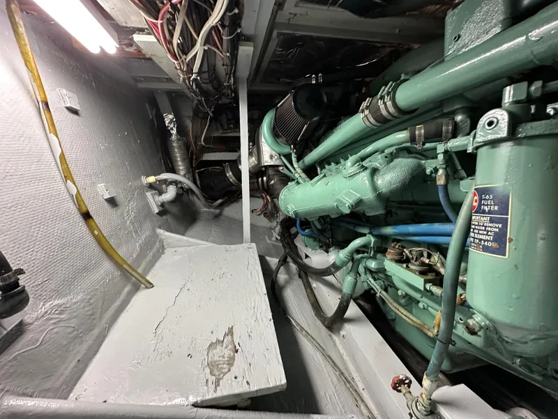Slide: The Image of Engine room of a 1978 Bertram 46 Convertible boat, showcasing mechanical components and wiring. - 27
