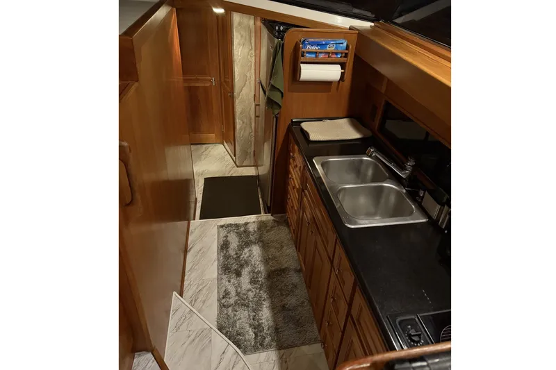 Slide: The Image of The galley of a 1978 Bertram 46 Convertible with double sink and wooden cabinets. - 15