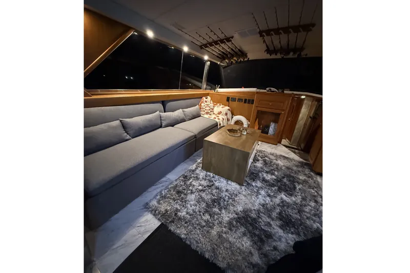 Slide: The Image of The interior of a 1978 Bertram 46 Convertible features a cozy seating area with a gray sofa and rug. - 16