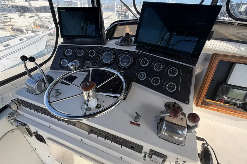 Slide: The Image of Cockpit of a 1978 Bertram 46 Convertible yacht with steering wheel and control panels. - 17