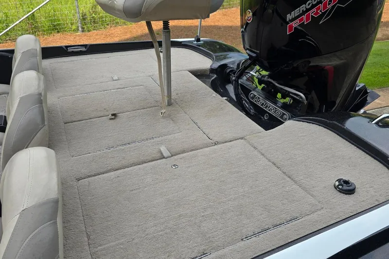 Slide: The Image of 2013 Nitro Z-6 boat interior with Mercury Pro motor, featuring cushioned seating and carpeted deck. - 11