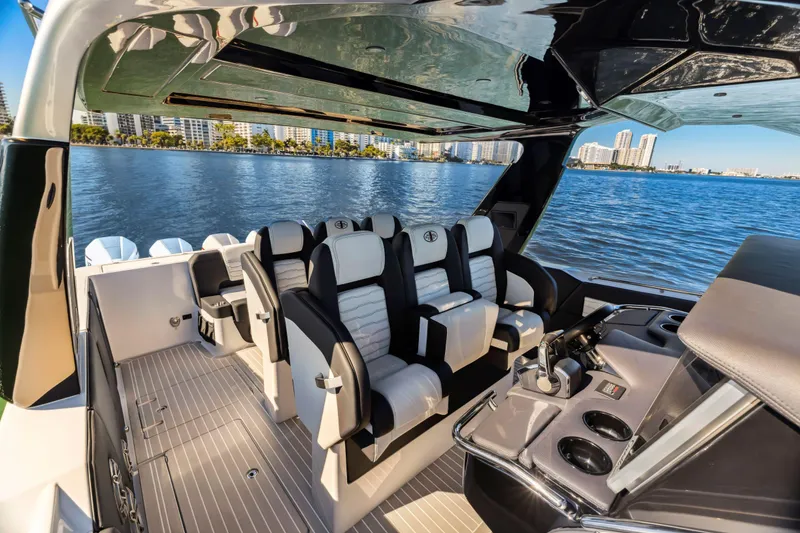 Slide: The Image of 2022 Cigarette 42 Auroris luxury boat interior with plush seating and modern dashboard, overlooking waterfront. - 23