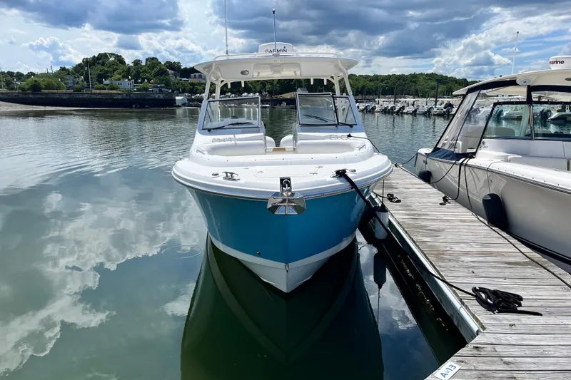 Slide: The Image of 2014 Edgewater 280CX Crossover boat docked on a calm, reflective water surface. - 3