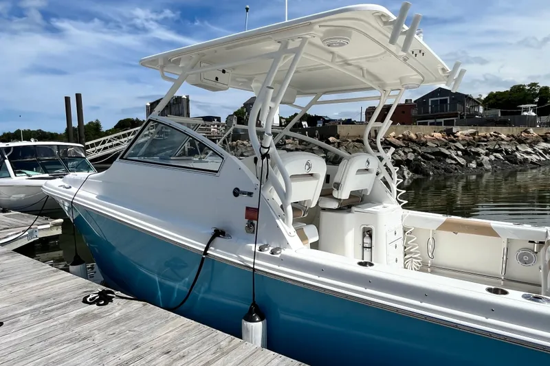 Slide: The Image of 2014 Edgewater 280CX Crossover boat docked at a marina under a clear blue sky. - 7