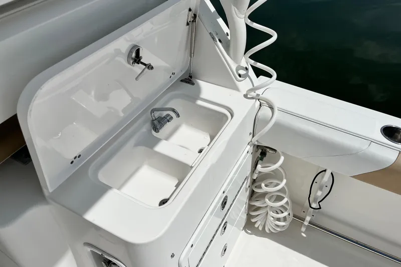 Slide: The Image of Edgewater 280CX Crossover 2014 boat sink with faucet and storage compartments. - 16