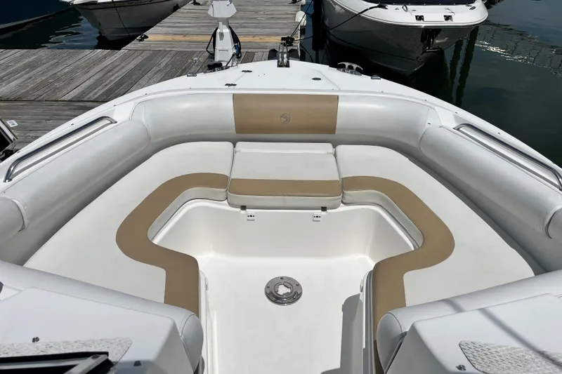 Slide: The Image of 2014 Edgewater 280CX Crossover boat interior with cushioned seating at dock. - 27