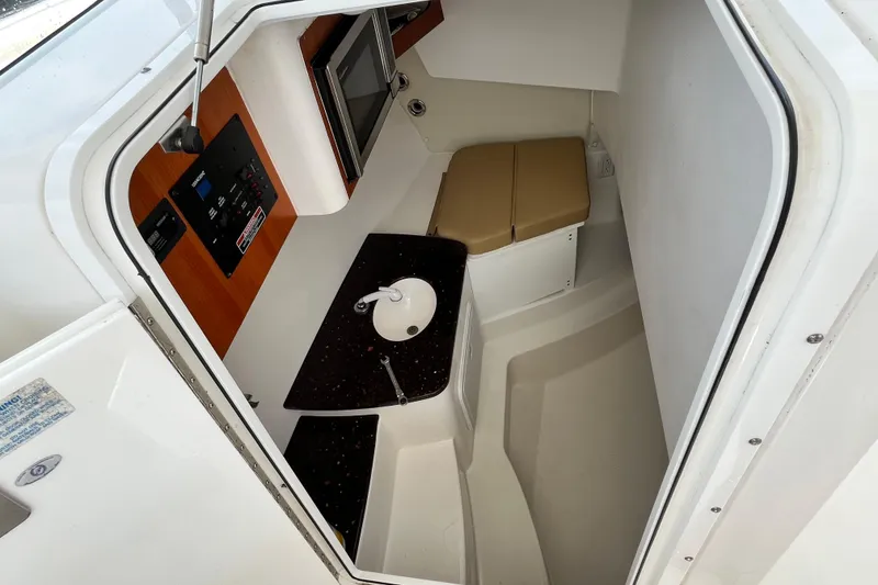 Slide: The Image of Interior cabin of 2014 Edgewater 280CX Crossover boat with sink and seating area. - 27