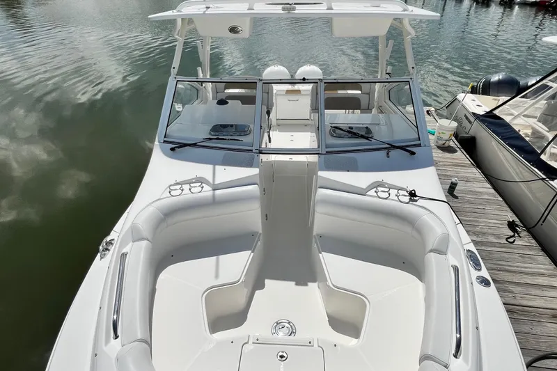 Slide: The Image of 2014 Edgewater 280CX Crossover boat docked, featuring spacious seating and sleek design. - 29