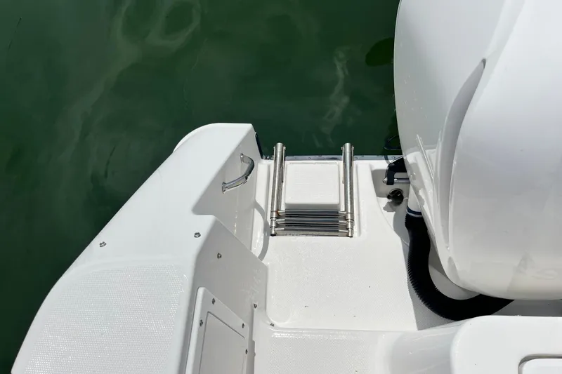 Slide: The Image of 2014 Edgewater 280CX Crossover boat with swim platform and ladder in calm water. - 35