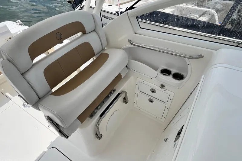 Slide: The Image of 2014 Edgewater 280CX Crossover boat interior with cushioned seating and storage compartments. - 19