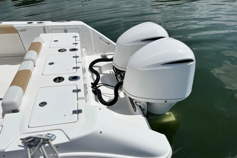 Slide: The Image of 2014 Edgewater 280CX Crossover boat with dual outboard engines on calm water. - 9
